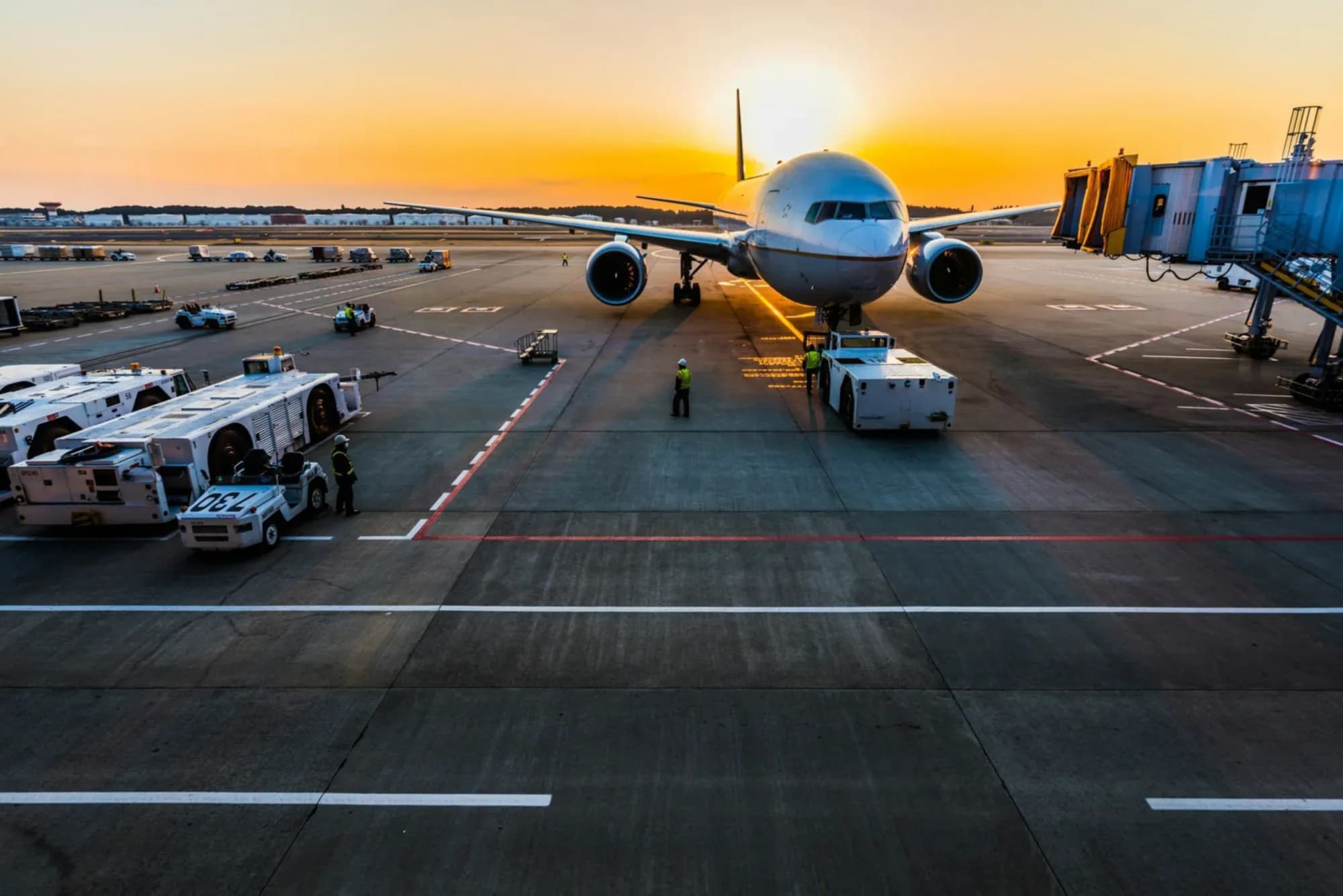 Avión en la plataforma del aeropuerto al atardecer, listo para cargar